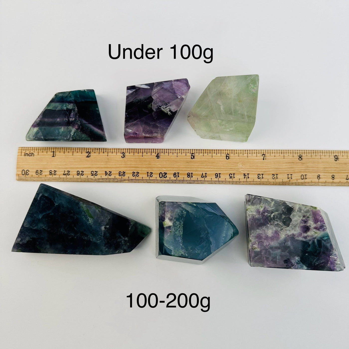 Rainbow Fluorite AA Grade Freeform - By Size next to a ruler for size reference