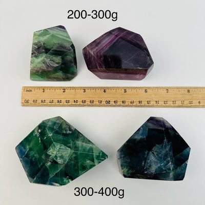 Rainbow Fluorite AA Grade Freeform - By Size next to a ruler for size reference 