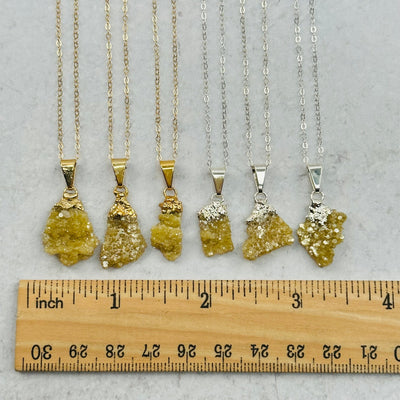 pendants next to a ruler to show the differences in the sizes 