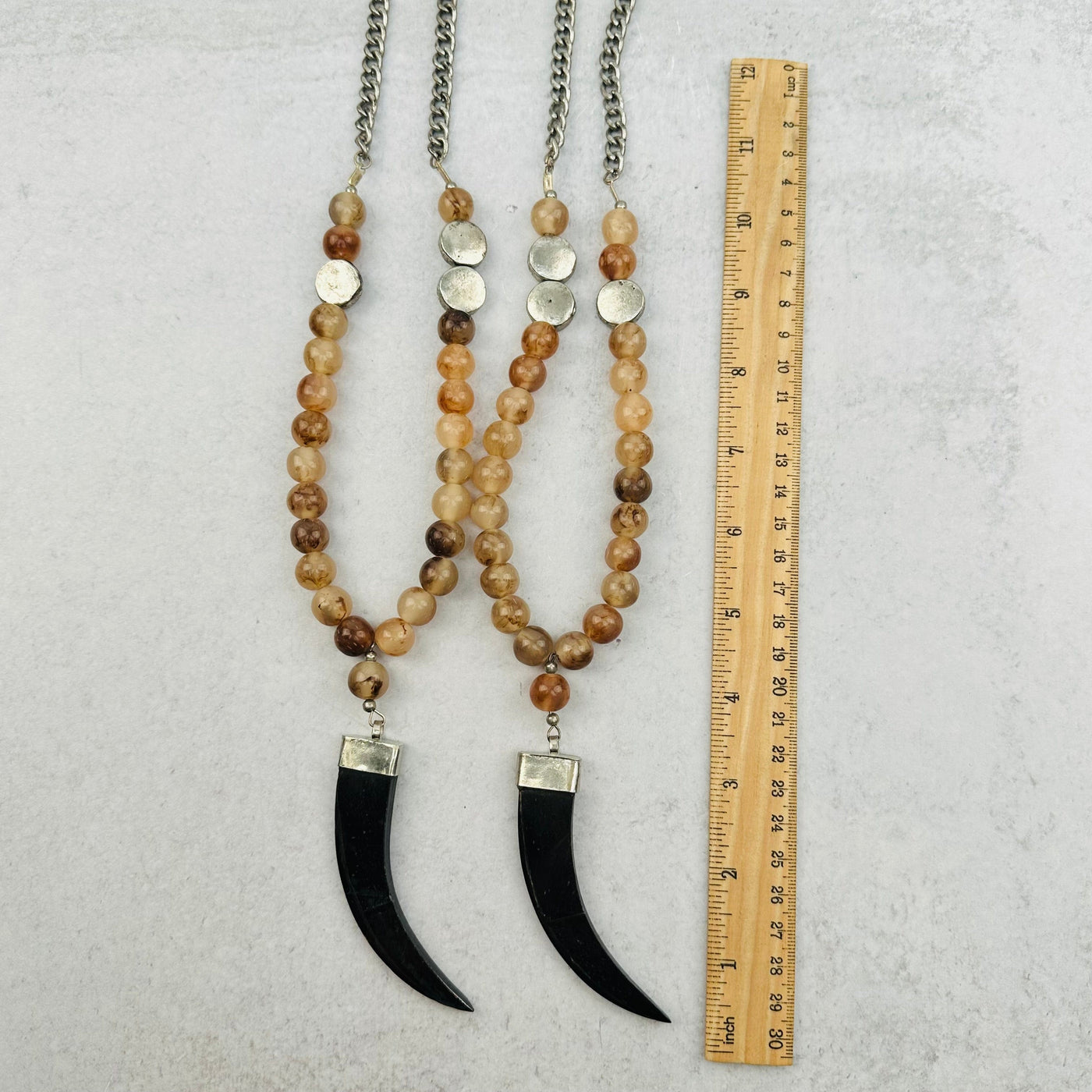 bottom portion of the necklace next to a ruler for size reference 