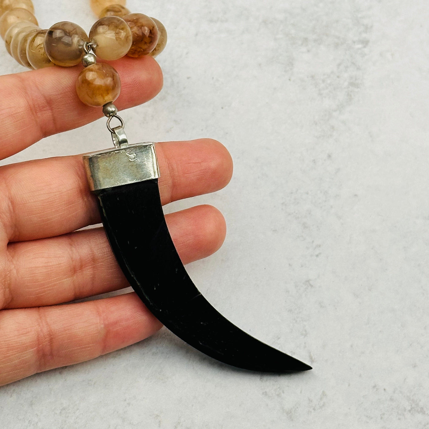 black horn pendant in hand for size reference 