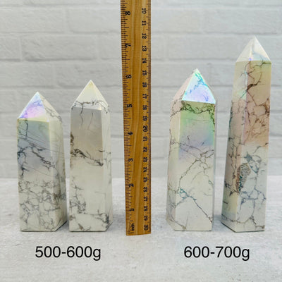 Howlite Tower Points with Angel Aura Titanium Finish - By Weight next to a ruler for size reference 