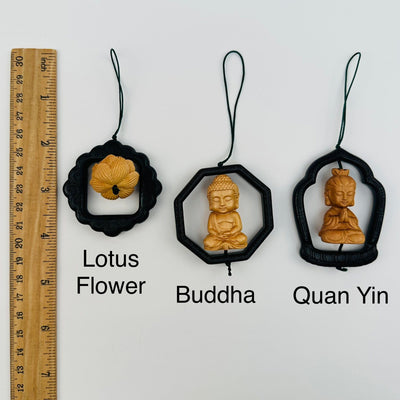 wooden charms displayed next to a ruler for size reference 