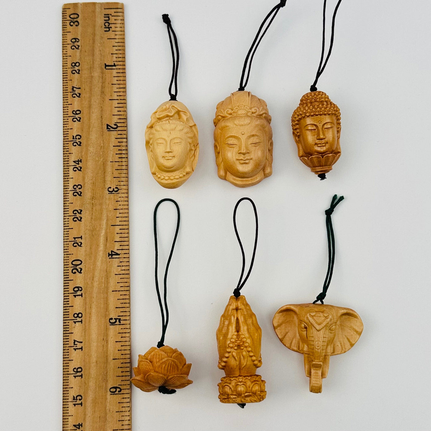 wooden charms next to a ruler for size reference 