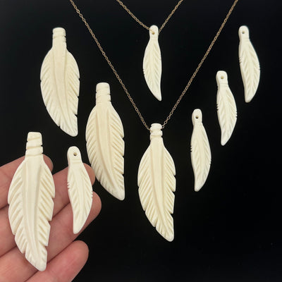 bone feather pendant in hand for size reference 