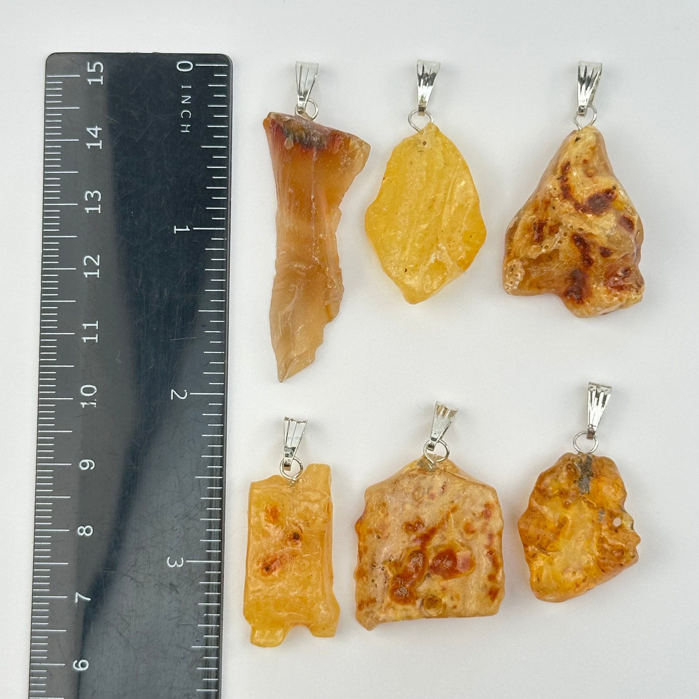 pendants next to a ruler for size reference 