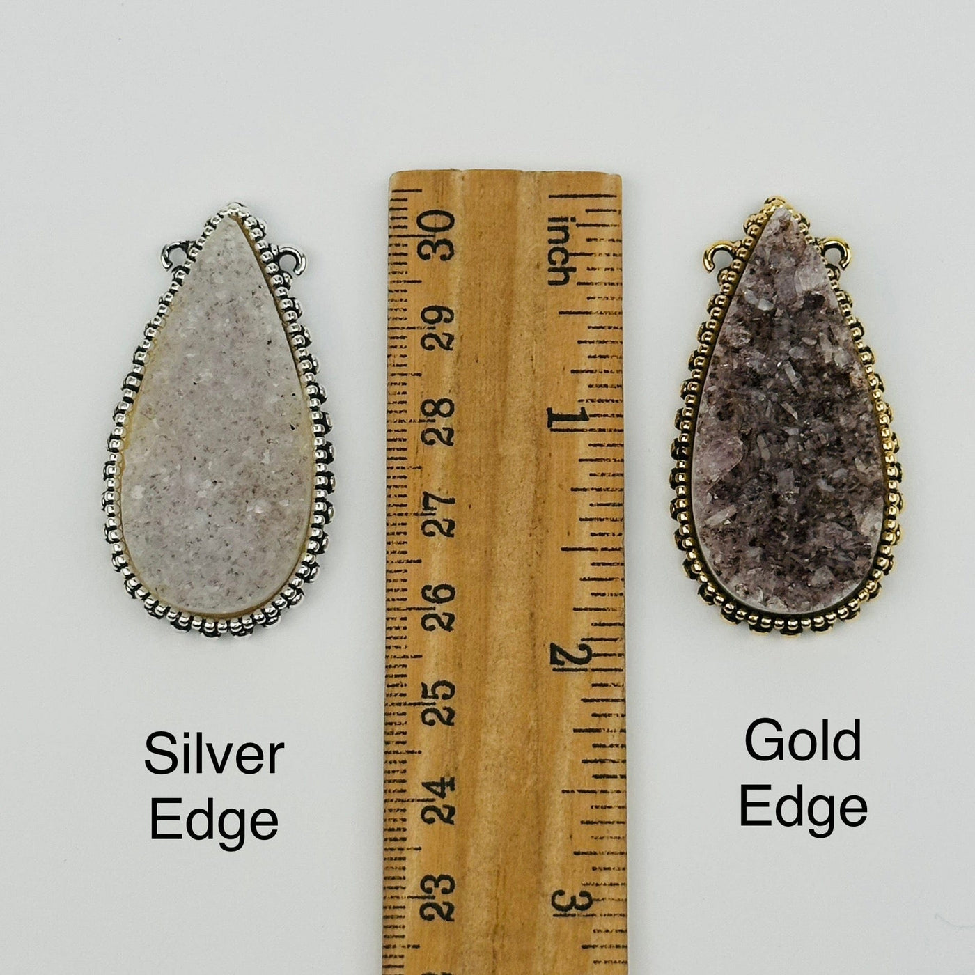 pendants next to a ruler for size reference 