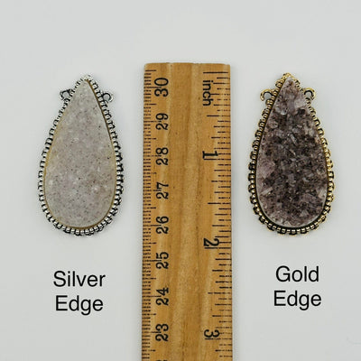 pendants next to a ruler for size reference 