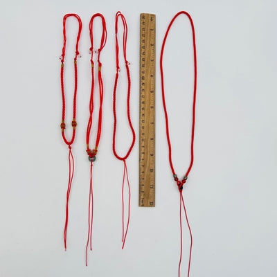 necklaces next to a ruler for size reference 