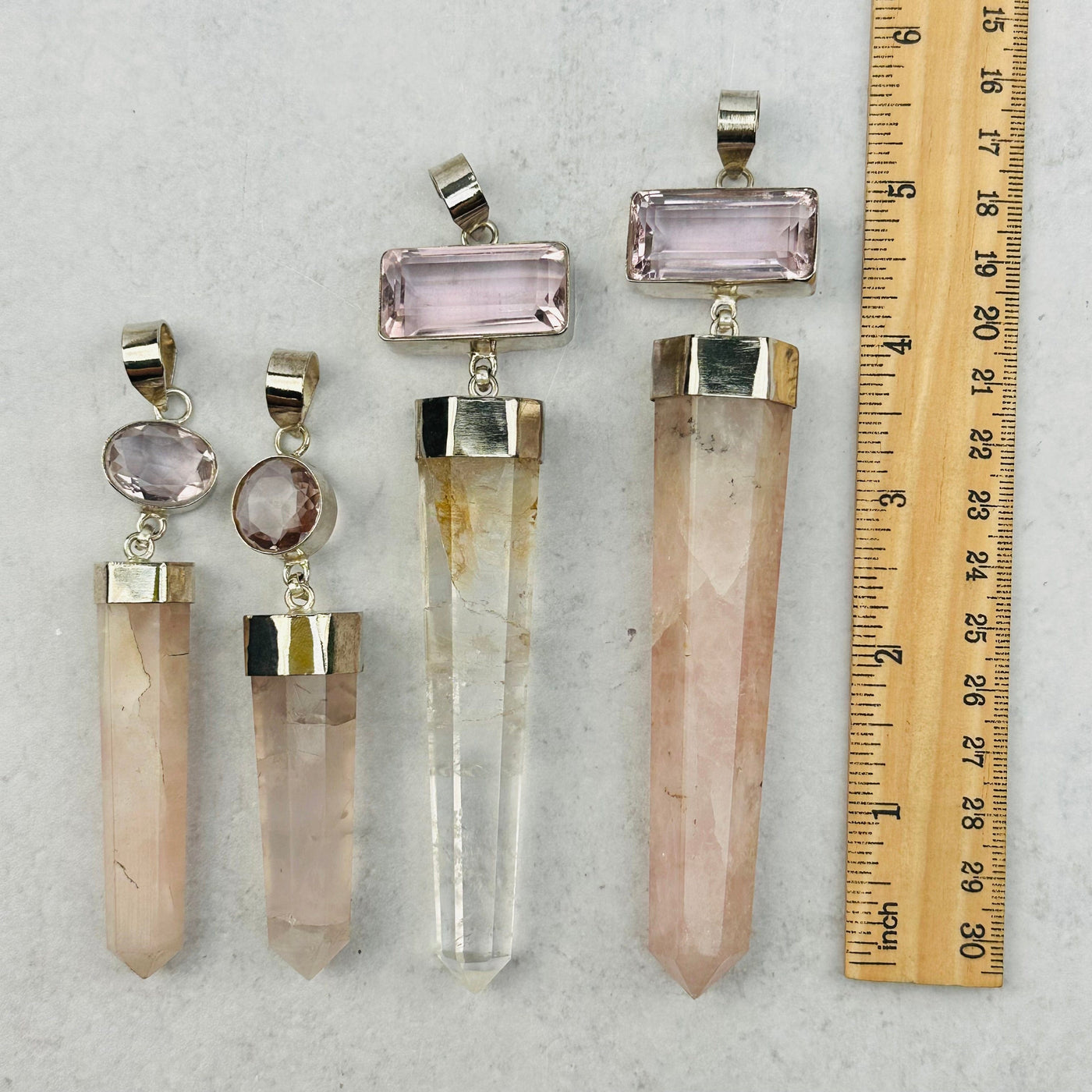 large pendants next to a ruler for size reference 