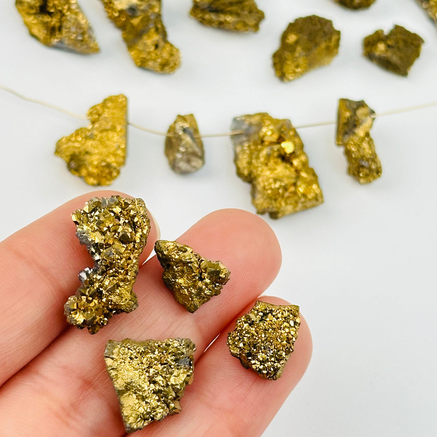 Gold Titanium Freeform Druzy Drilled Beads in hand for size reference 