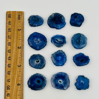 solar quartz crystals displayed next to a ruler for size reference  