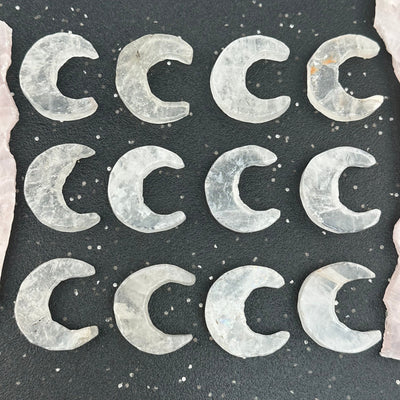 multiple crystal quartz crescents displayed to show the differences in the sizes and color shades 