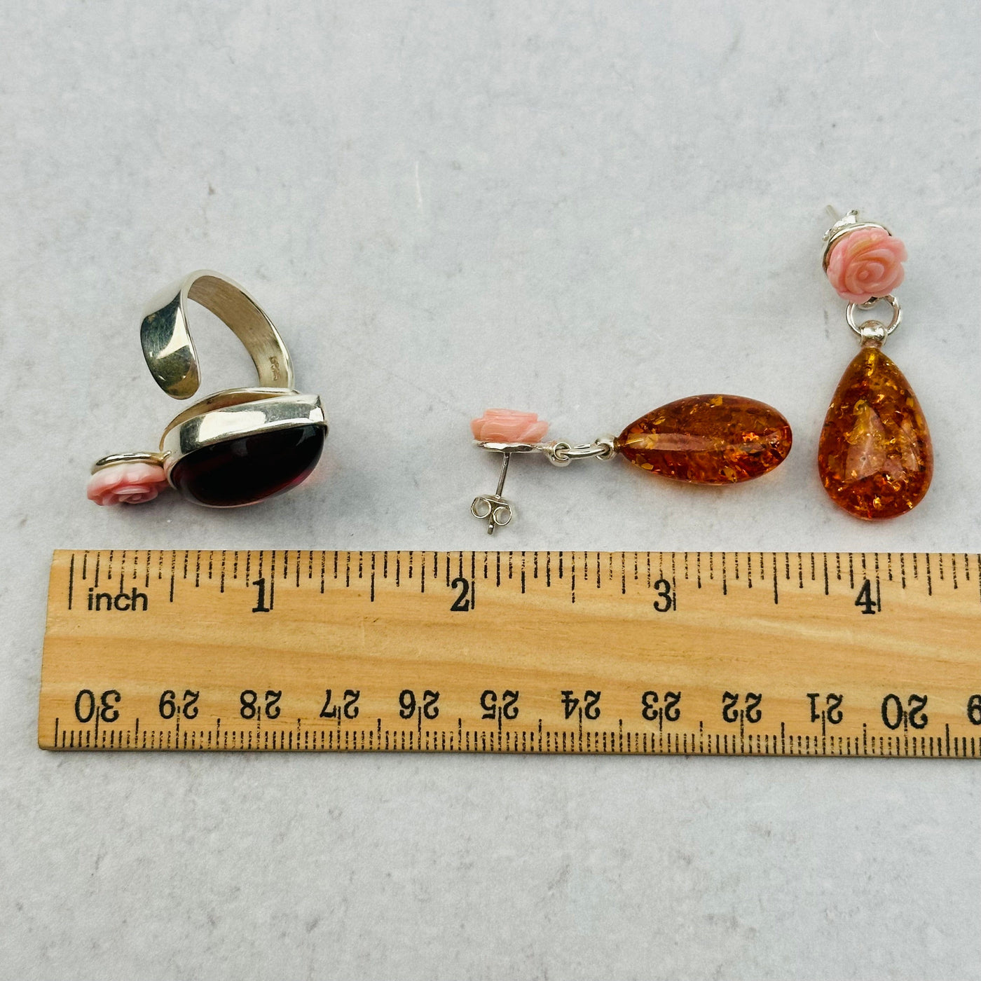 amber jewelry next to a ruler for size reference 
