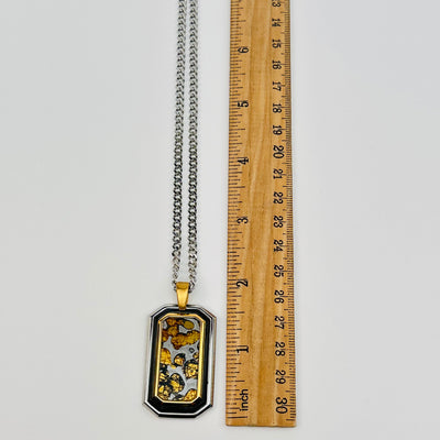 Sericho Pallasaite Meteorite Crystal pendant displayed next to a ruler for size reference 
