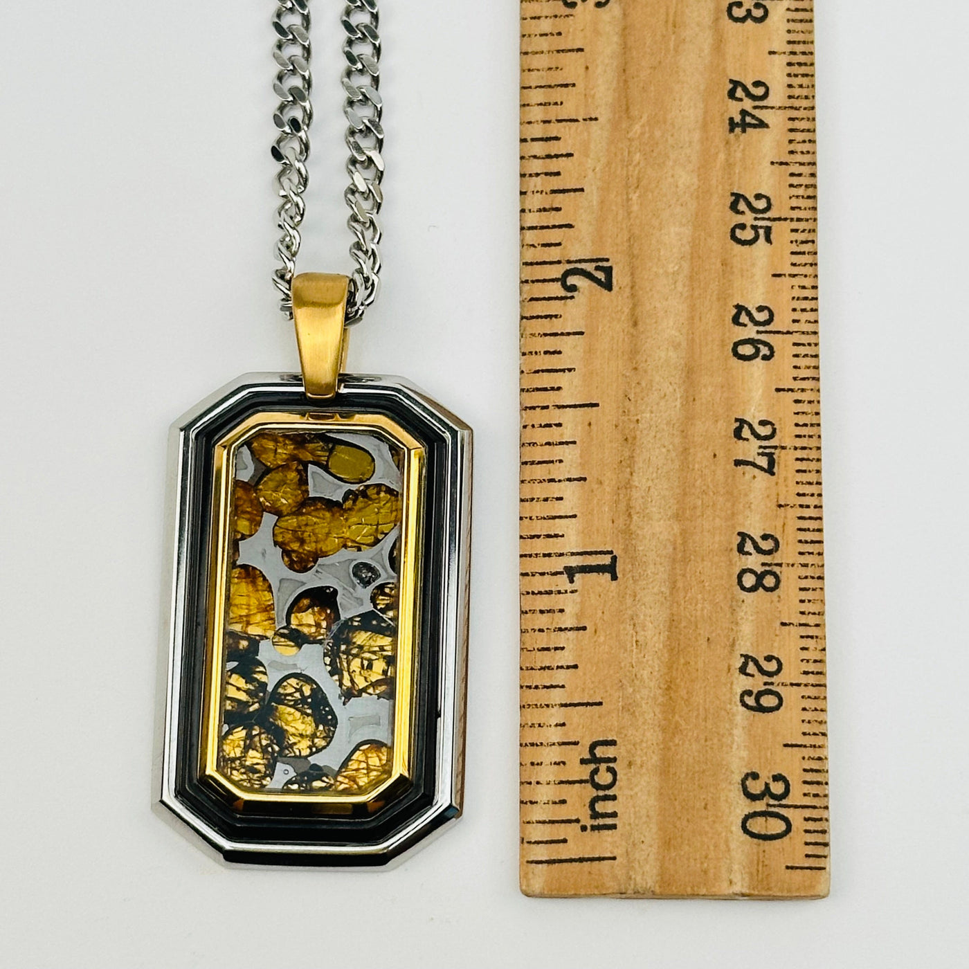 Sericho Pallasaite Meteorite Crystal pendant displayed next to a ruler for size reference 
