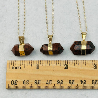 pendants next to a ruler to show the slight differences in the sizes 