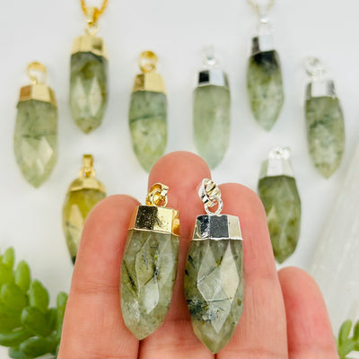 prehnite crystal pendants in hand for size reference 