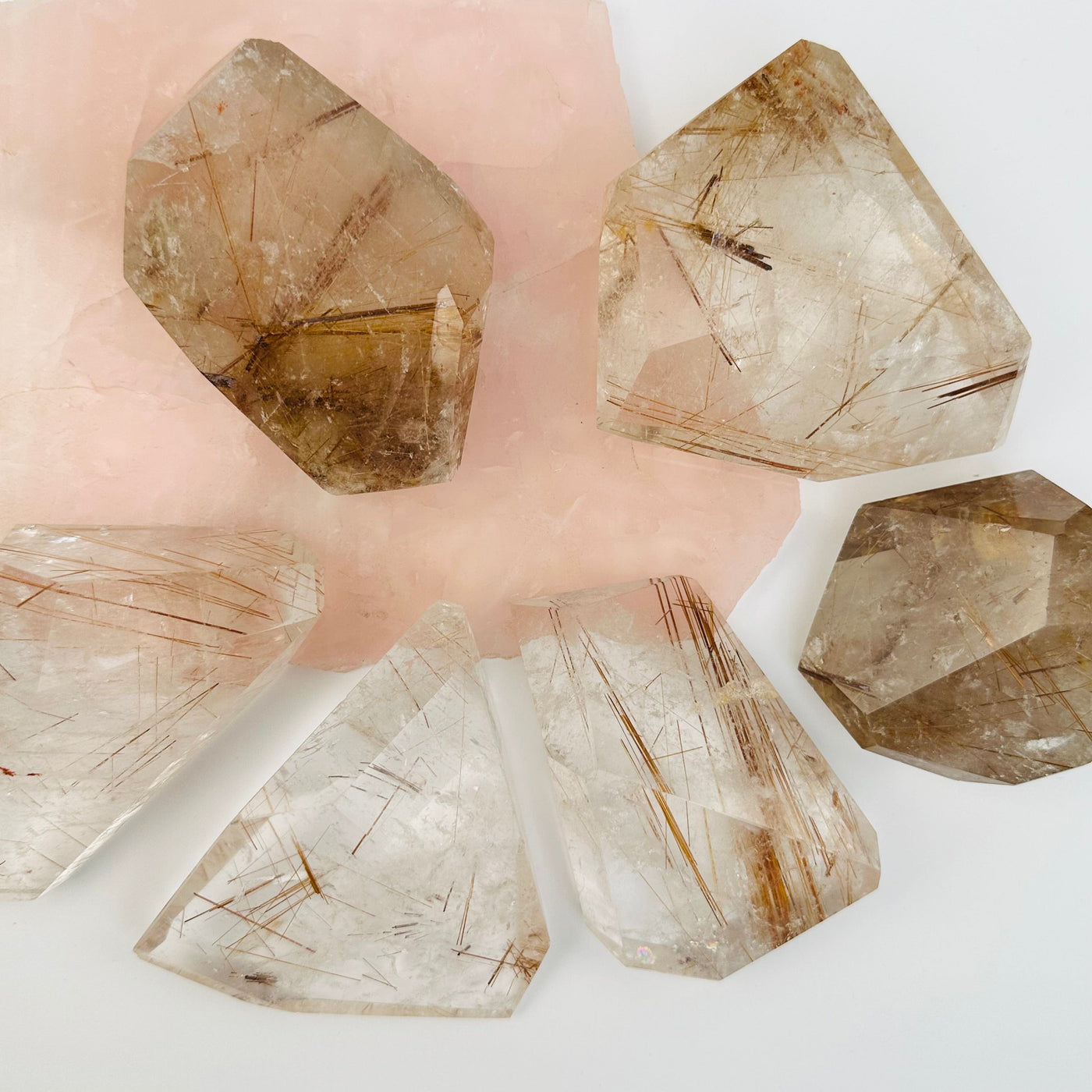 multiple rutilated crystal quartz displayed to show the differences in the sizes and color shades 