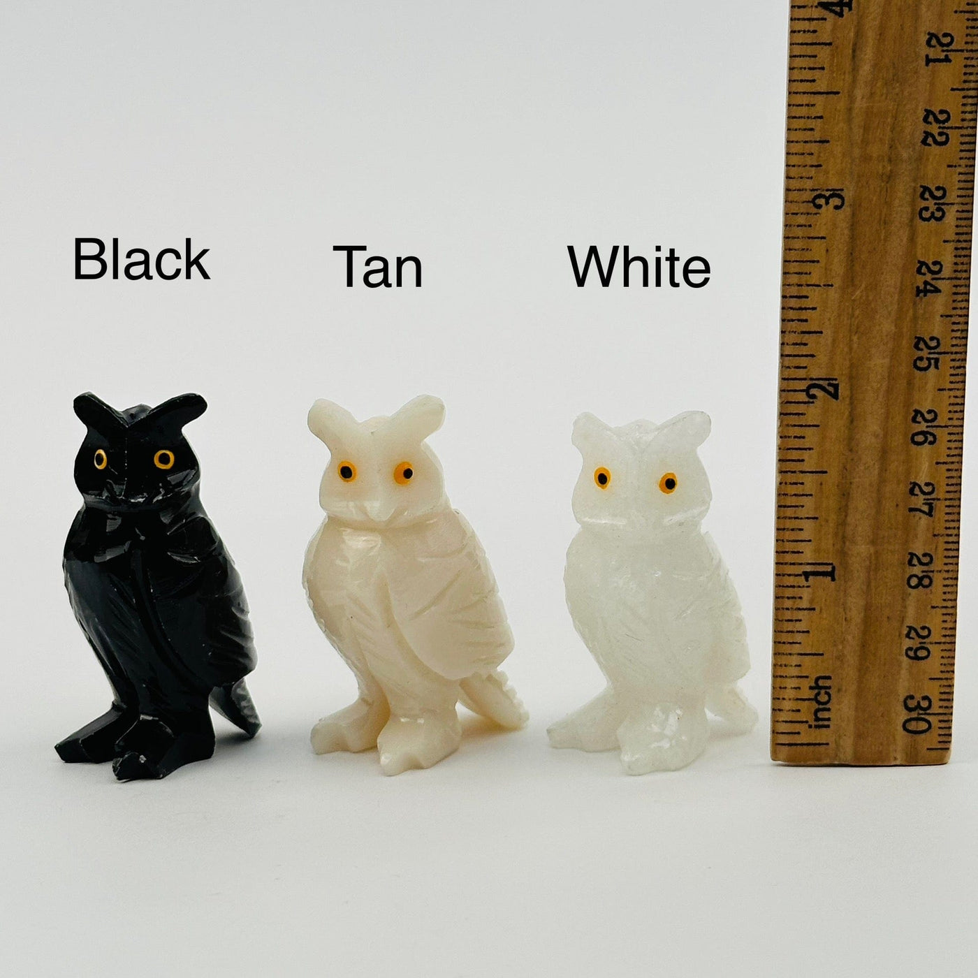 soapstone crystal owls displayed next to a ruler for size reference  