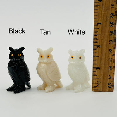 soapstone crystal owls displayed next to a ruler for size reference  