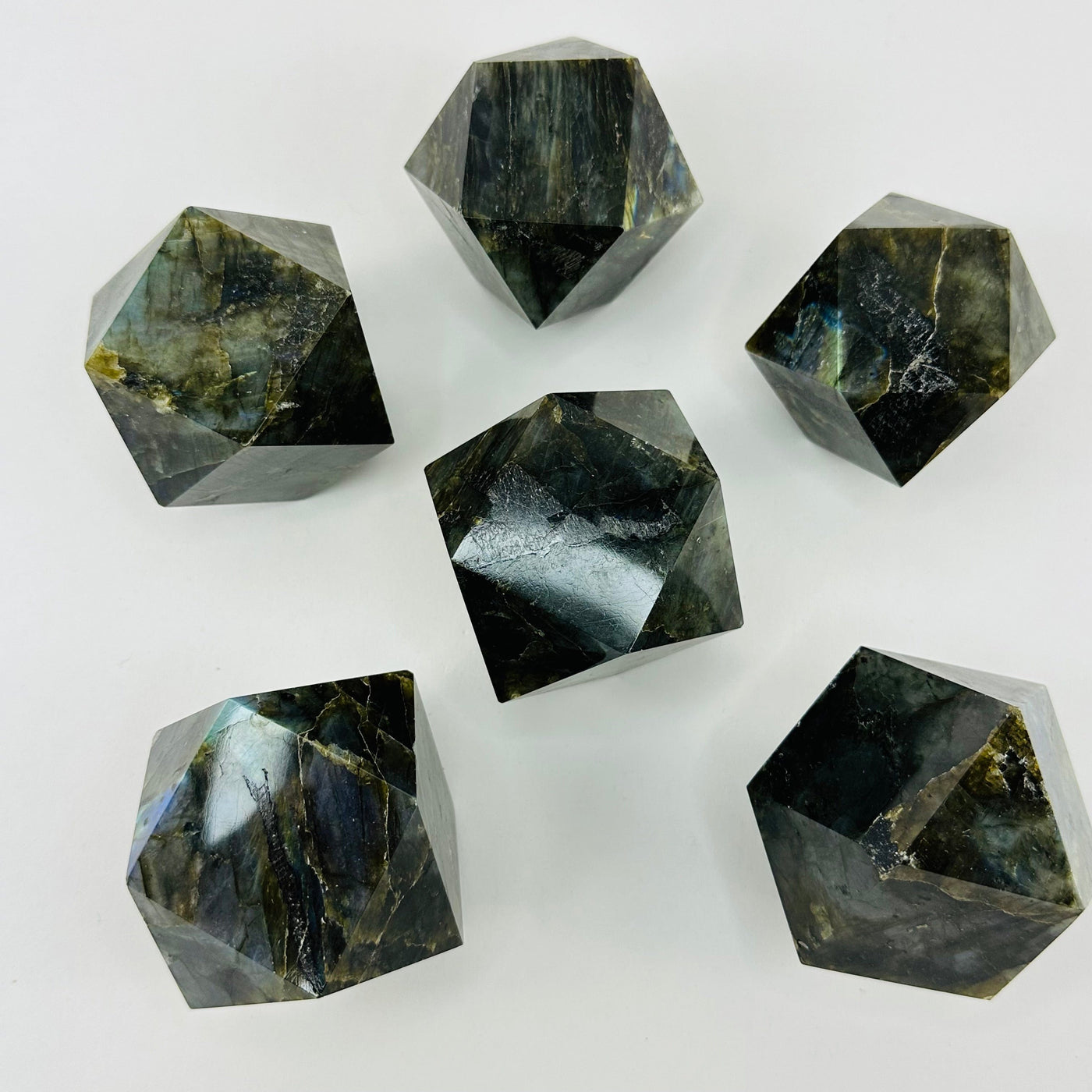 multiple labradorite geometric shapes displayed to show the differences in the sizes and color shades 