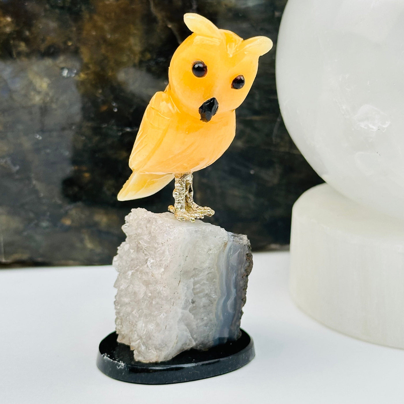 orange calcite owl on amethyst crystal base displayed as home decor 