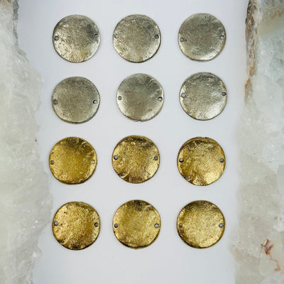 multiple brass charms displayed to show the differences in the color shades 