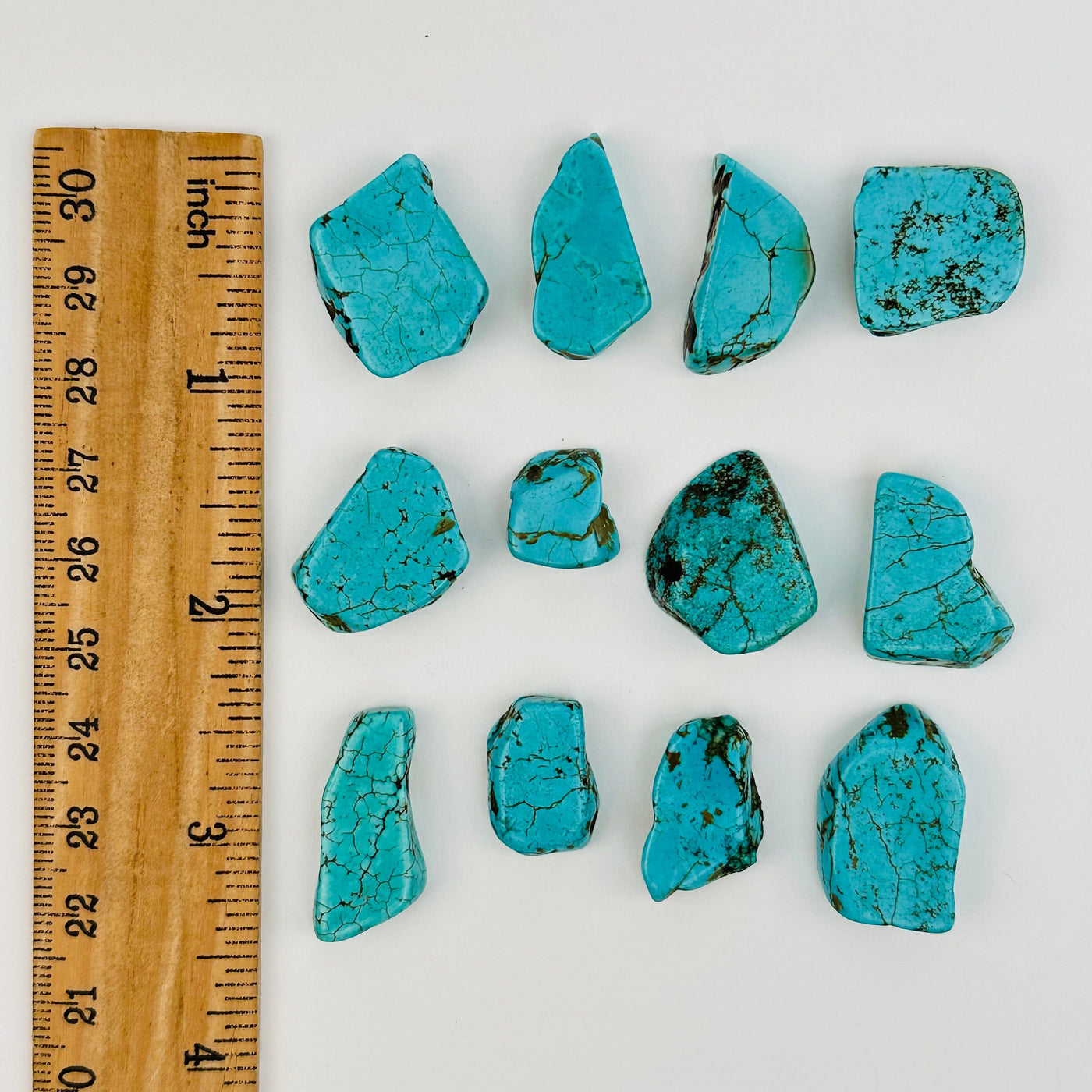 turquoise crystal beads displayed next to a ruler for size reference 