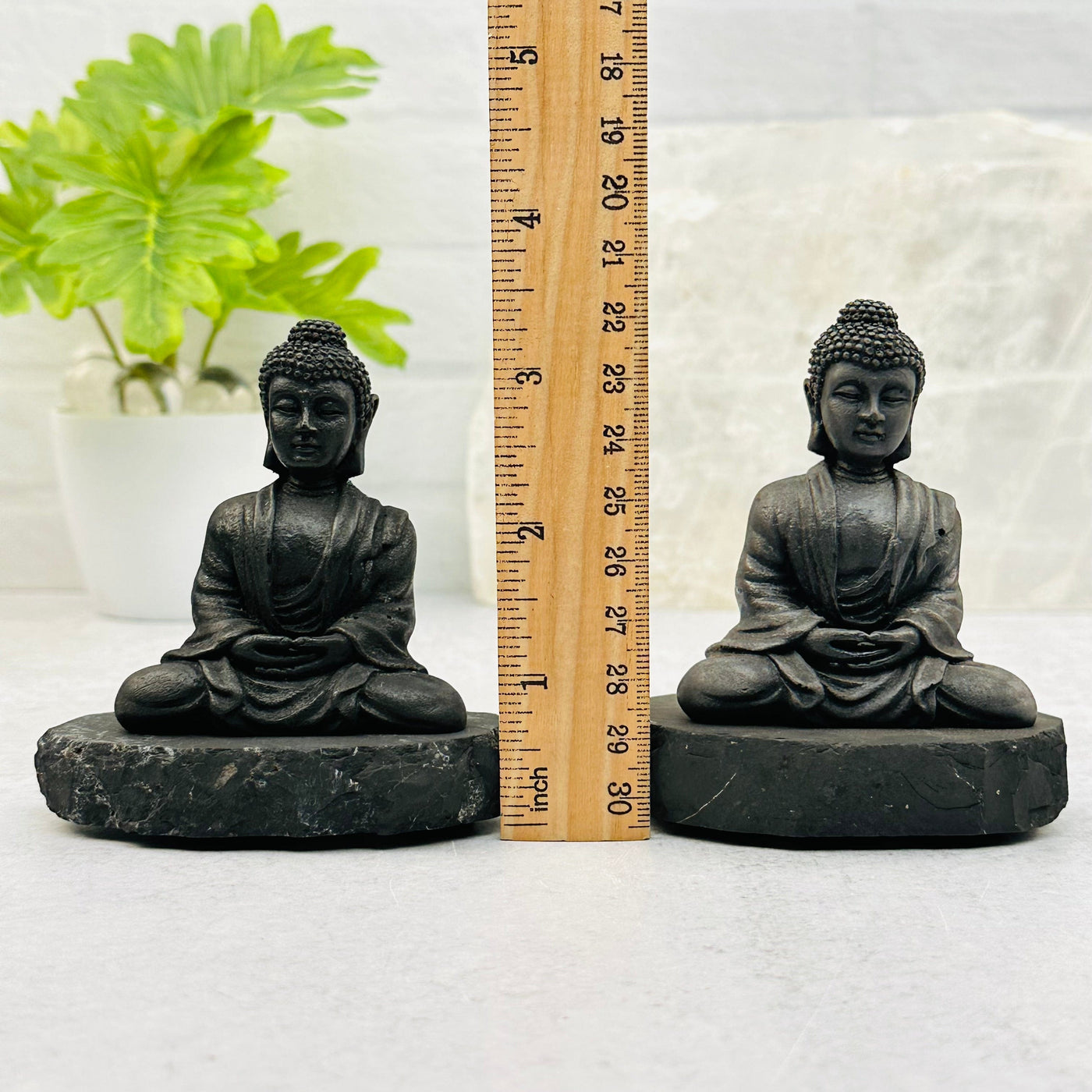 Shungite Sitting Buddha next to a ruler for size reference 