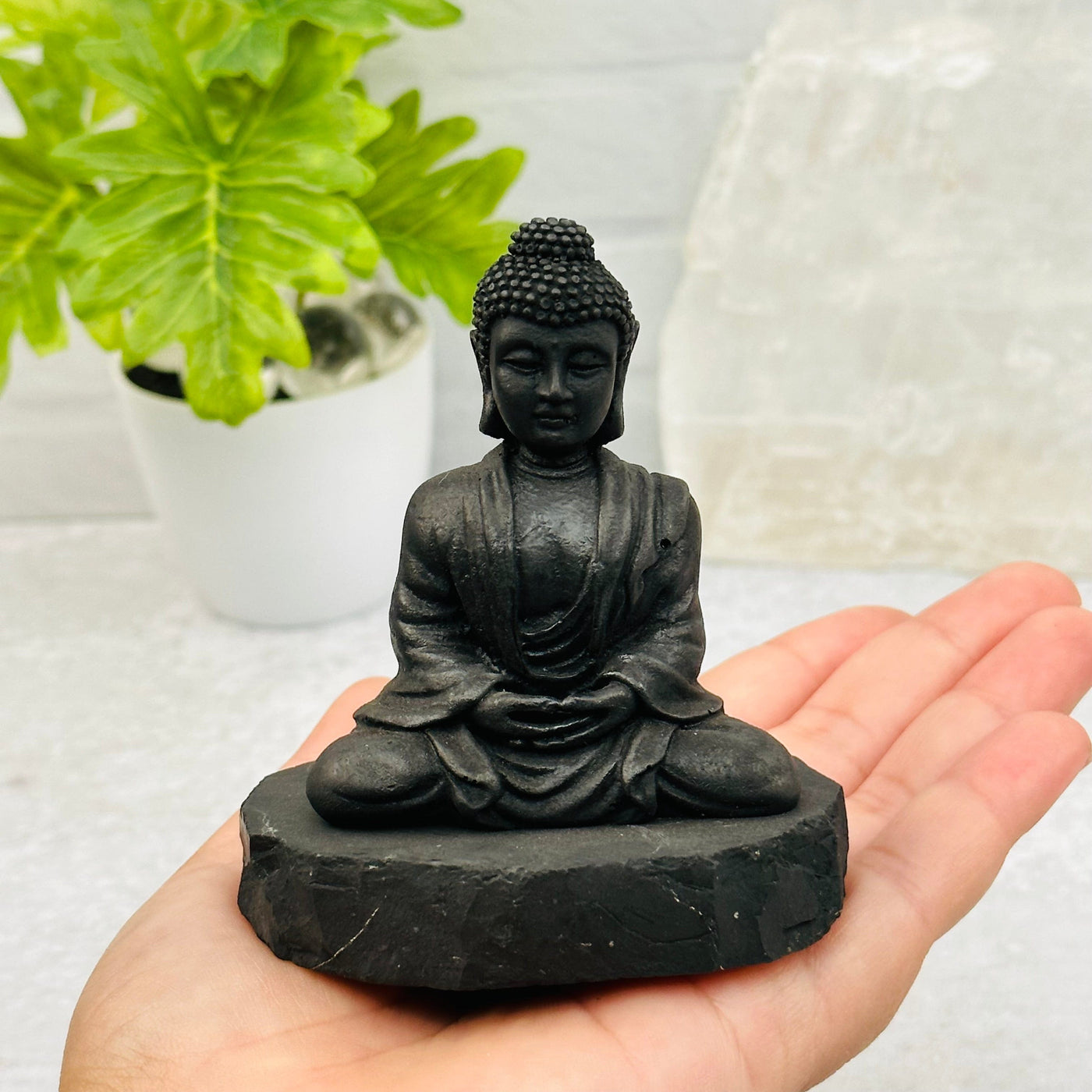 Shungite Sitting Buddha in hand for size reference 
