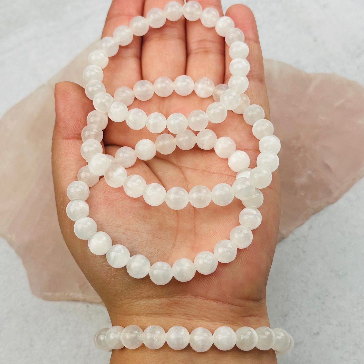 Selenite Round Bead Bracelets 8mm Beads in hand for size reference 