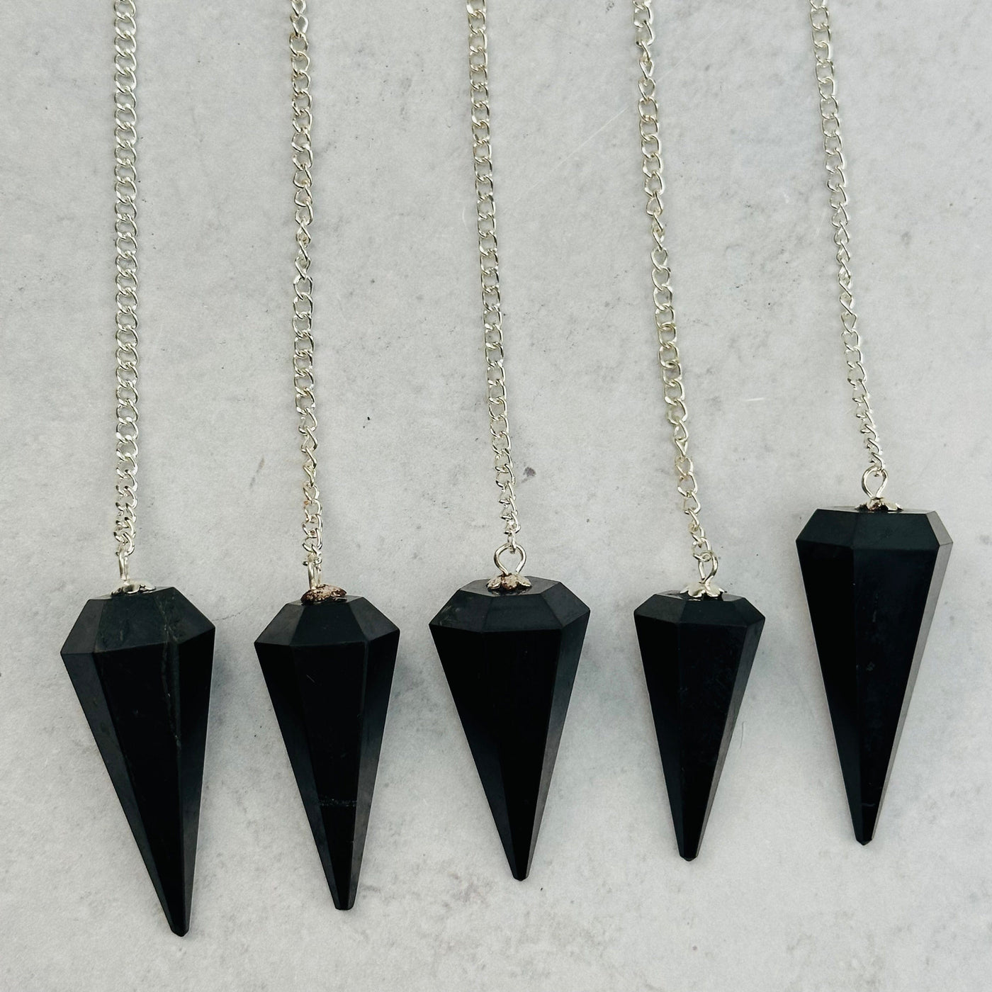 multiple Shungite Pendulums displayed to show the differences in the sizes 