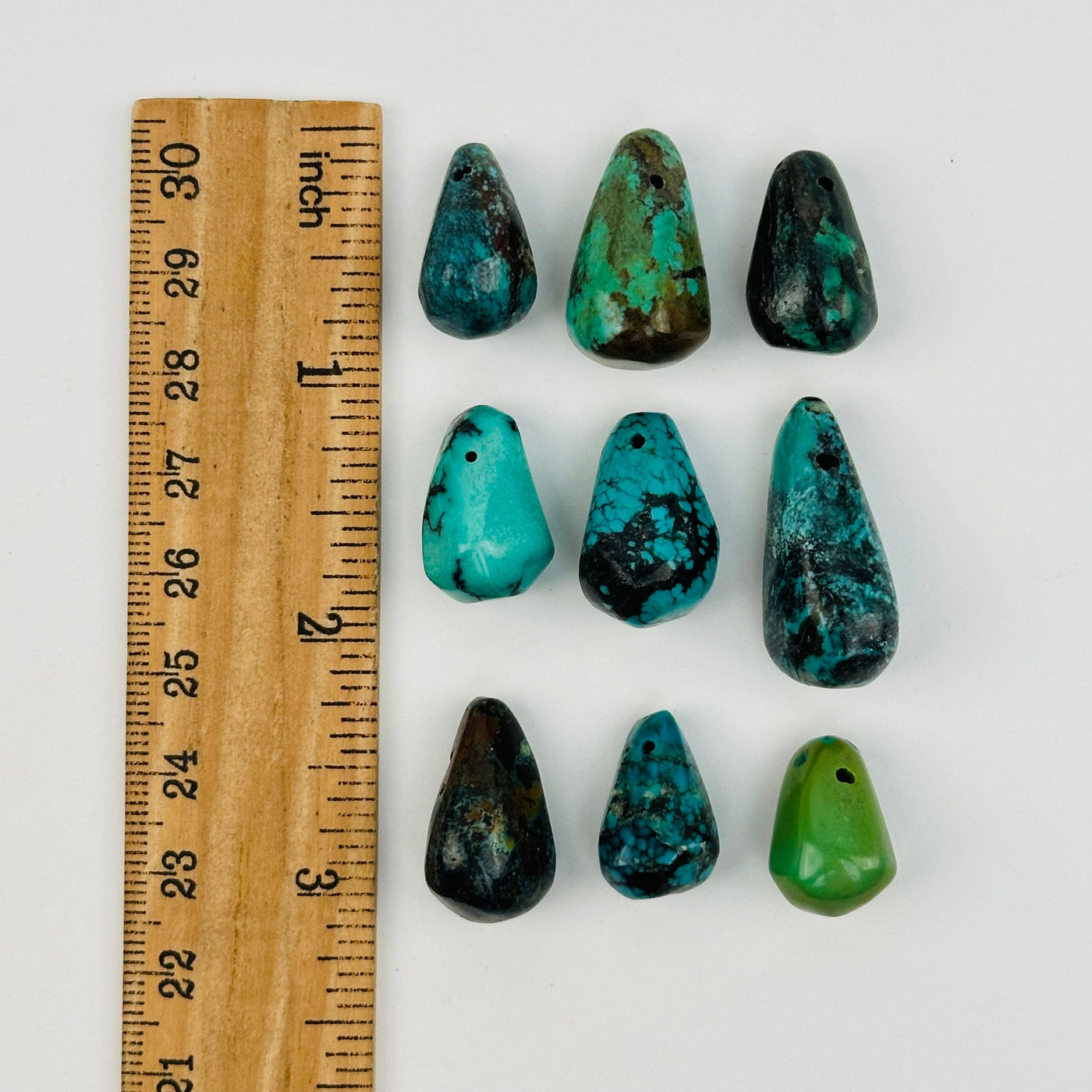 turquoise crystal beads displayed next to a ruler for size reference  