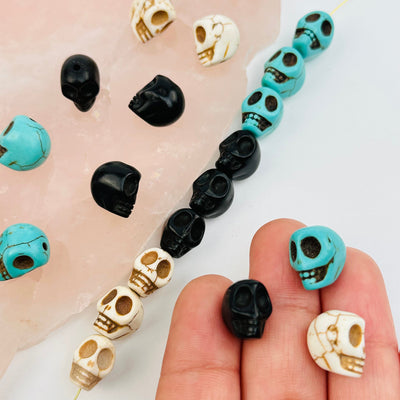 Turquoise Magnesite Skull Beads in hand for size reference 