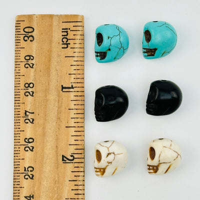 skull beads displayed next to a ruler for size reference 
