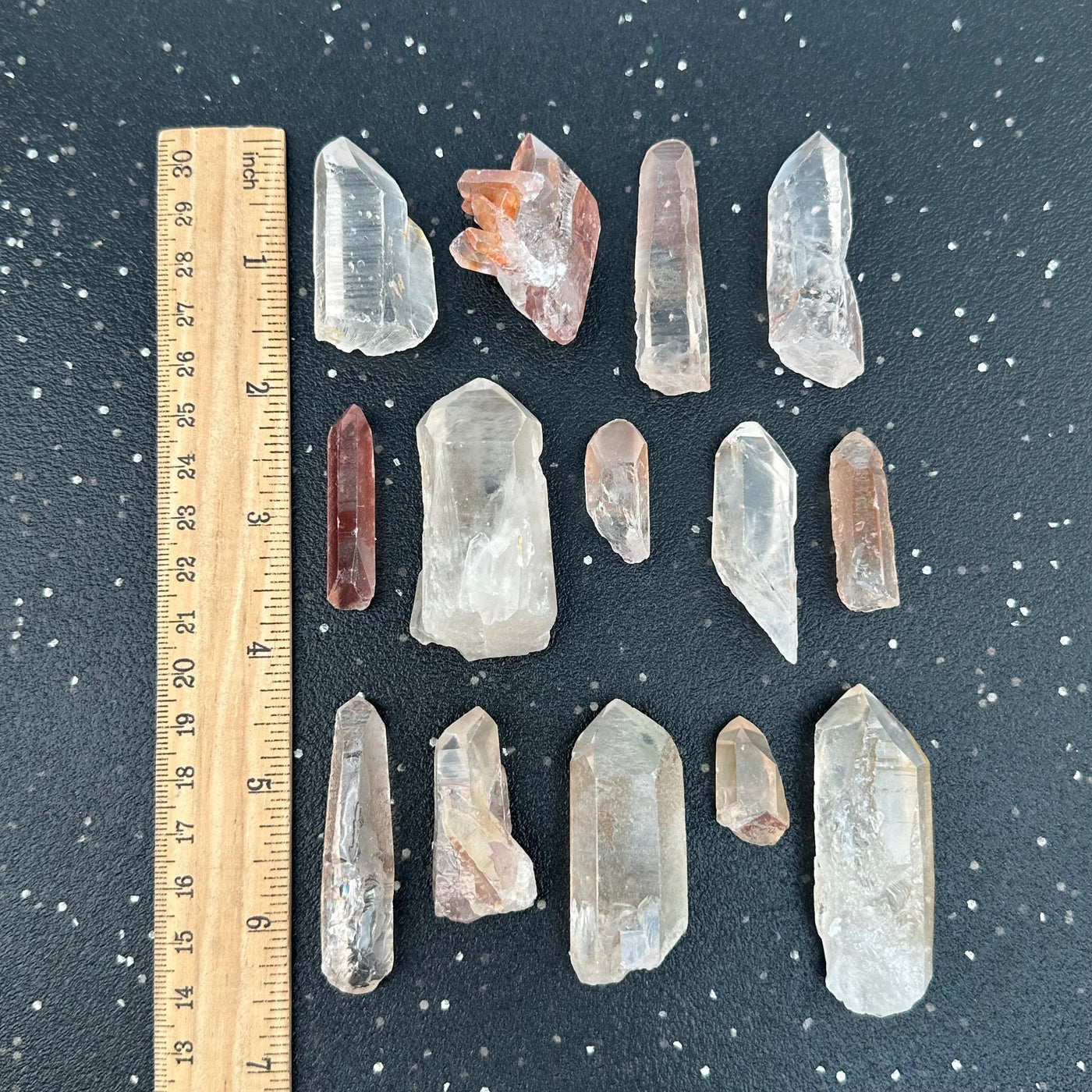 Lemurian Tangerine Crystal Points displayed next to a ruler for size reference 