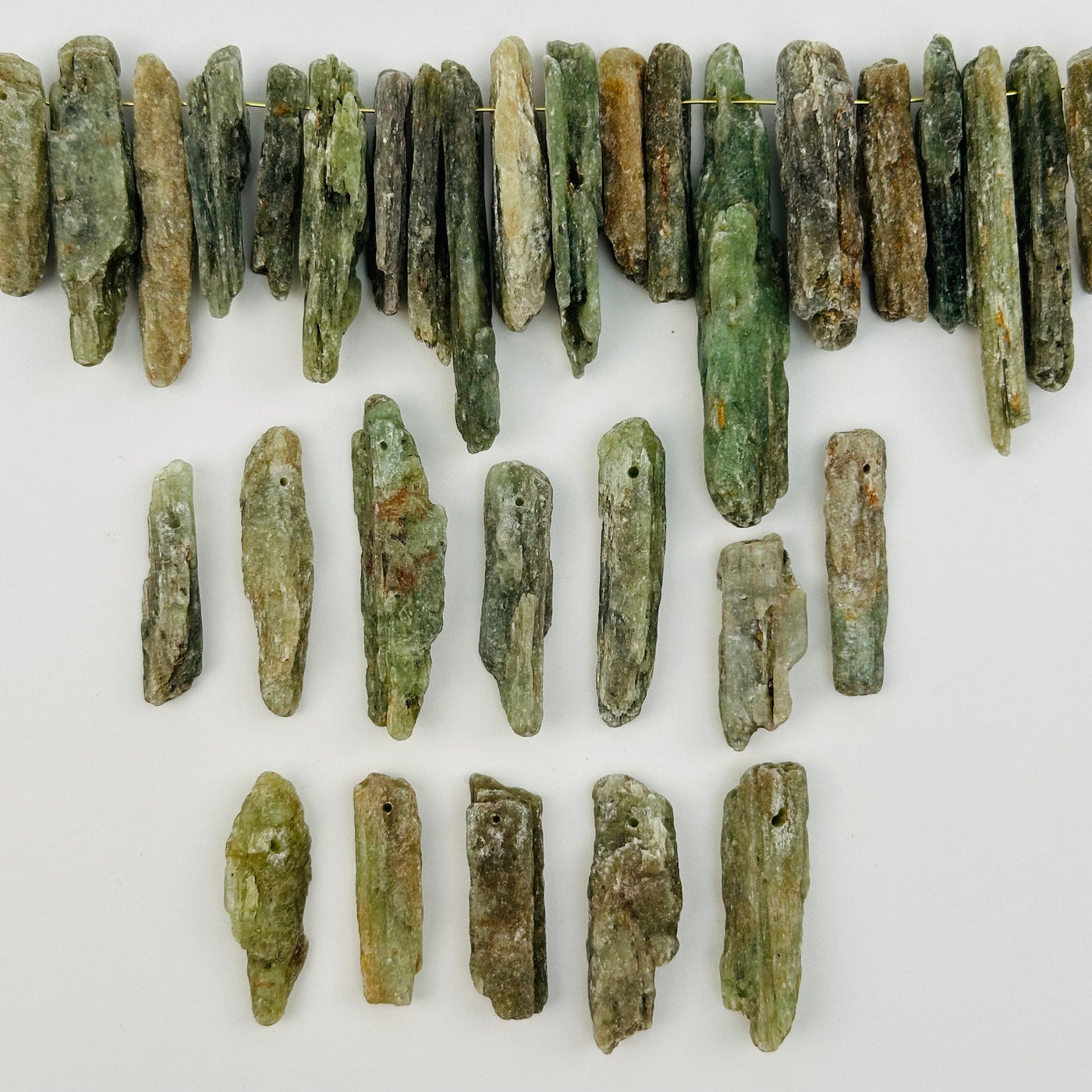 multiple Green Kyanite Free Form Crystal Beads displayed to show the differences in the sizes and color shades  