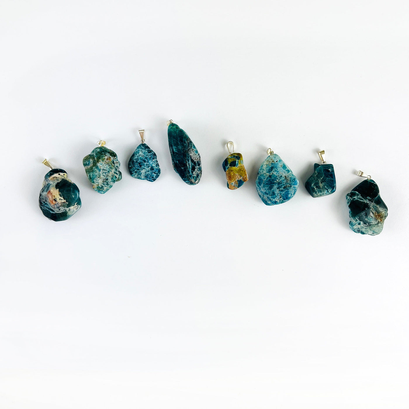 Apatite Polished Freeform Crystal Pendants with Silver Bails on a table showing varying sizes