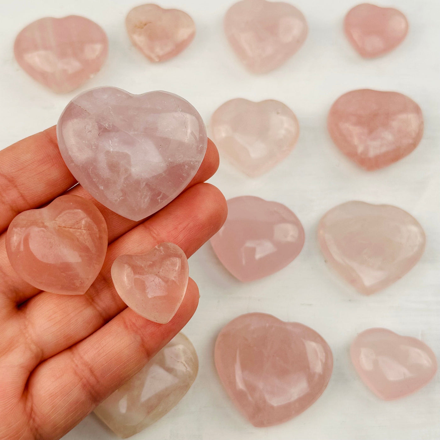 Rose Quartz Hearts in hand for size reference 