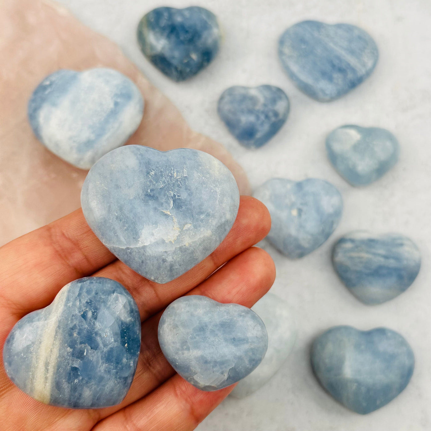 Blue Calcite Hearts in hand for size reference 