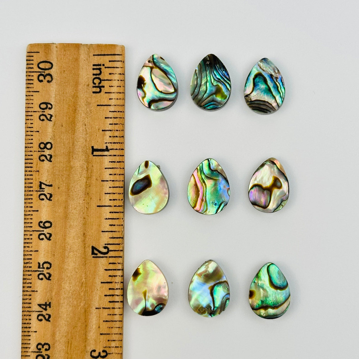 multiple cabochons displayed on a ruler for size reference 