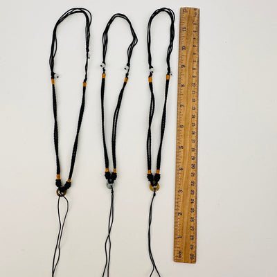 necklaces displayed next to a ruler for size reference 