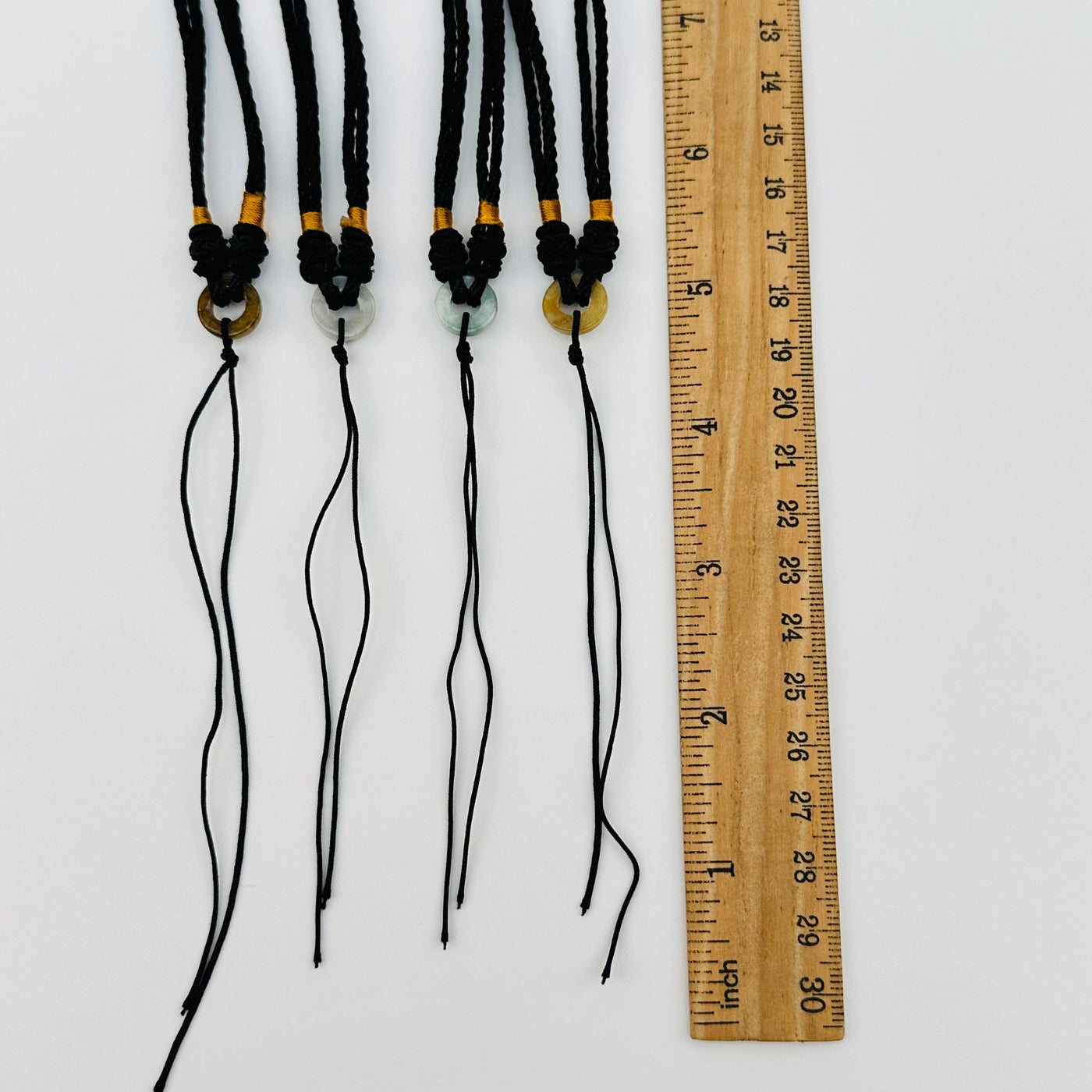 jade ring necklaces next to a ruler for size reference 