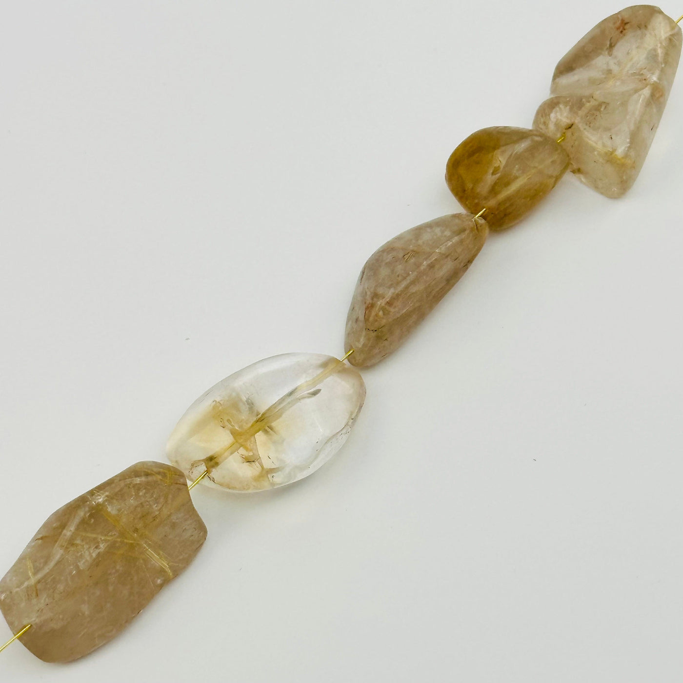 beads strung on string to show where it is drilled from 