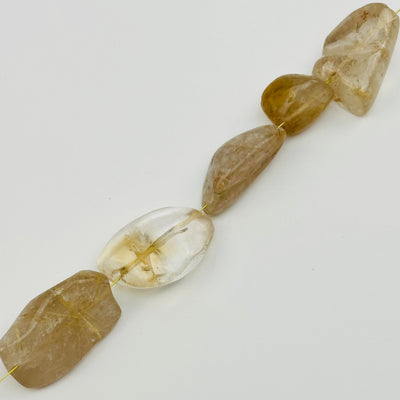 beads strung on string to show where it is drilled from 