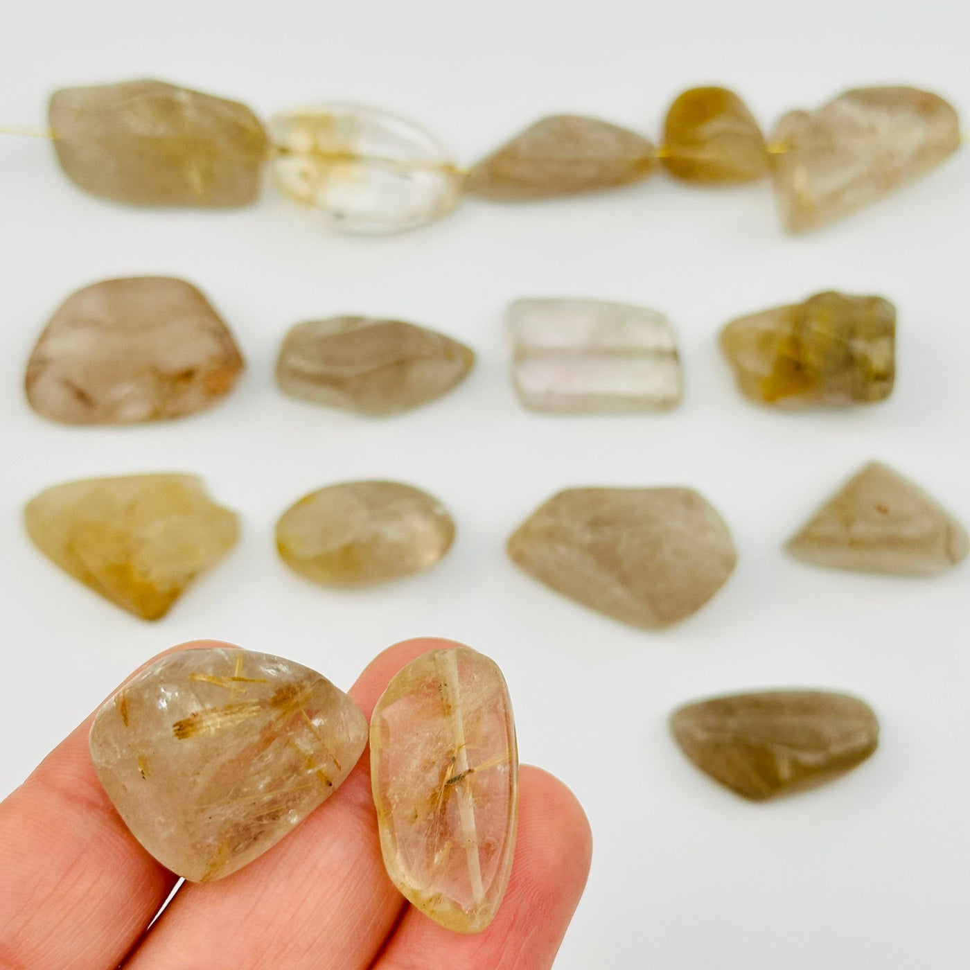 Rutilated Crystal Quartz Tumbled Beads in hand for size reference 