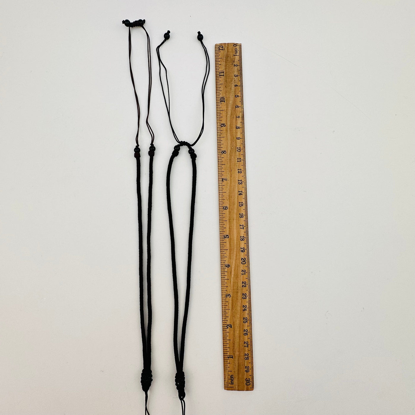 necklaces displayed next to a ruler for size reference 