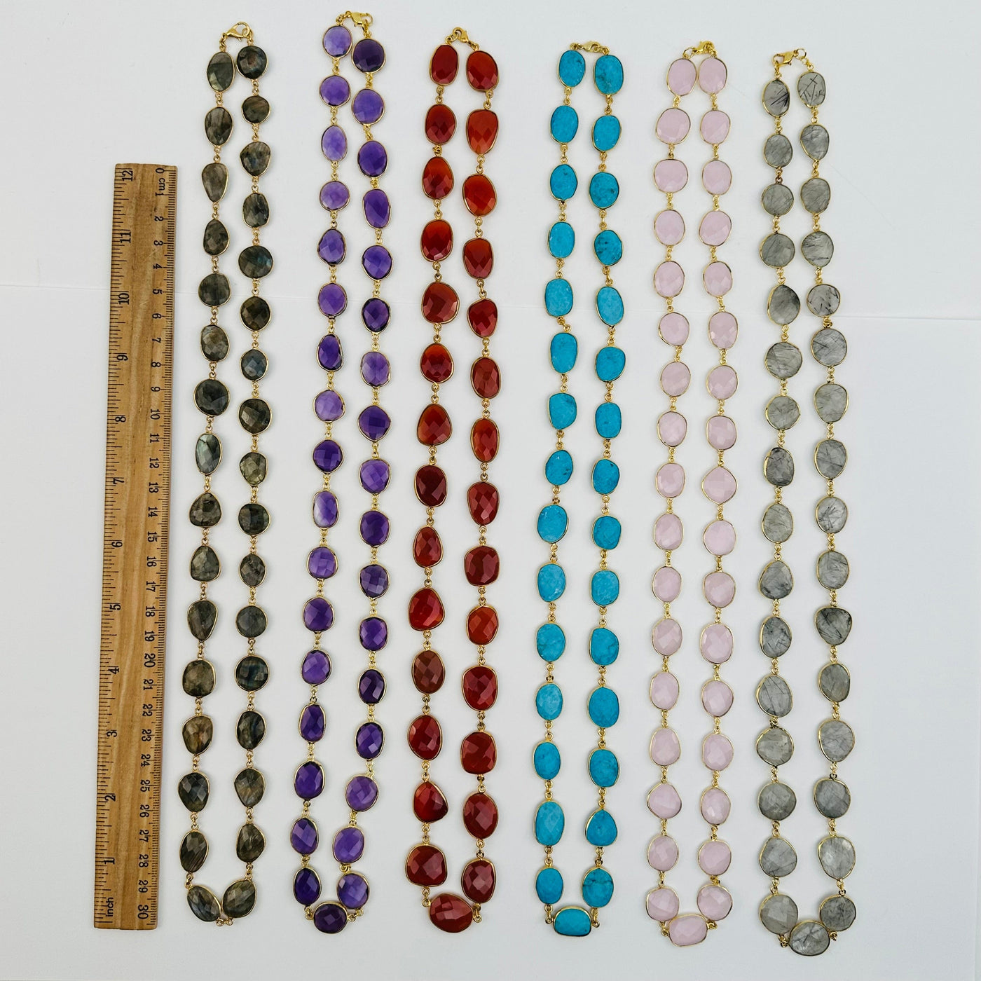 necklaces displayed next to a ruler for size reference 
