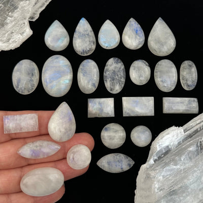 multiple Moonstone Crystal Cabochons on hand for size reference  